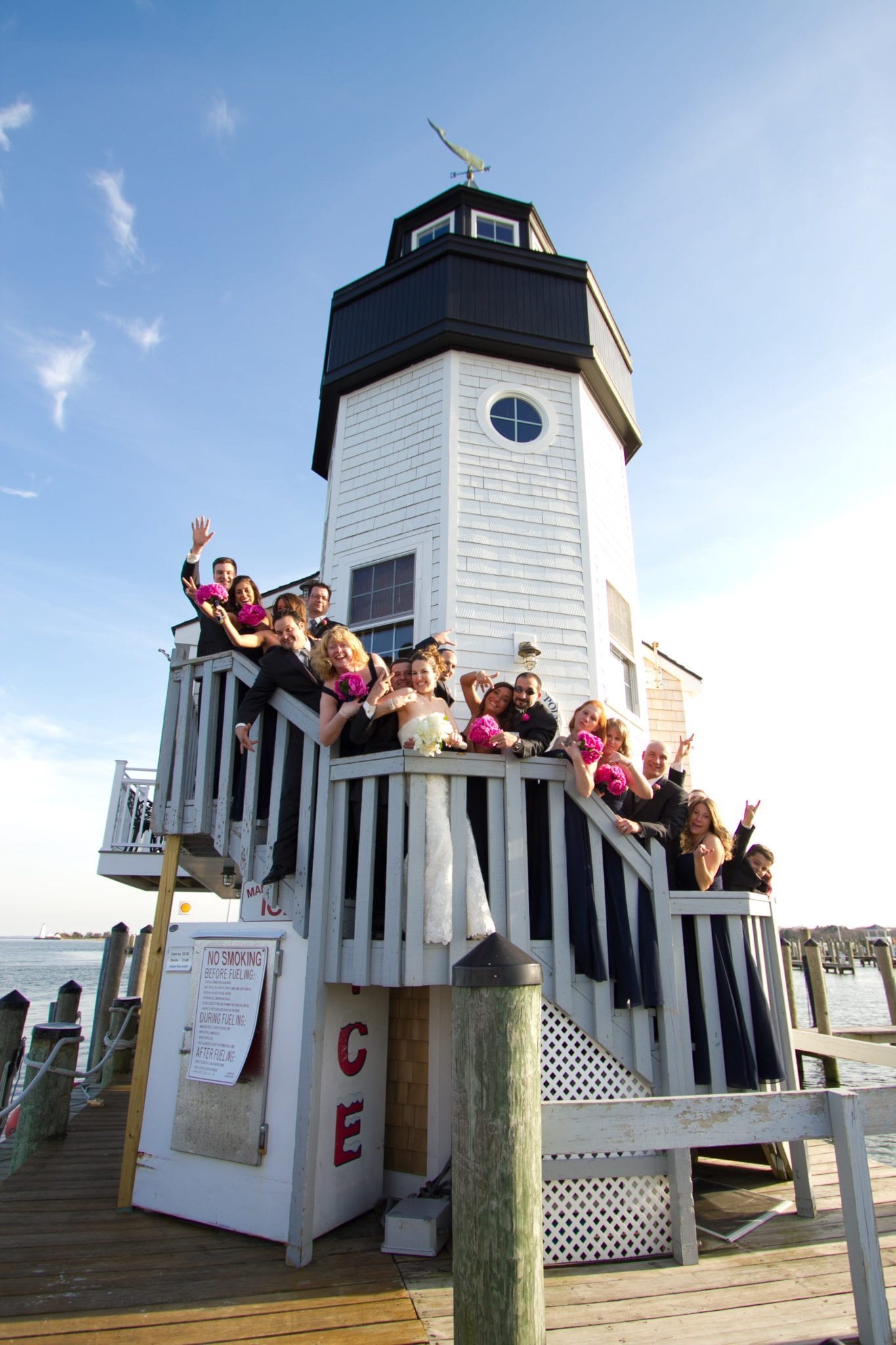 Wedding party posing on stairs of lighthouse.