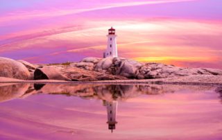 A lighthouse can be seen, illuminated by a pink-purple sunset, in romantic Old Saybrook, CT.
