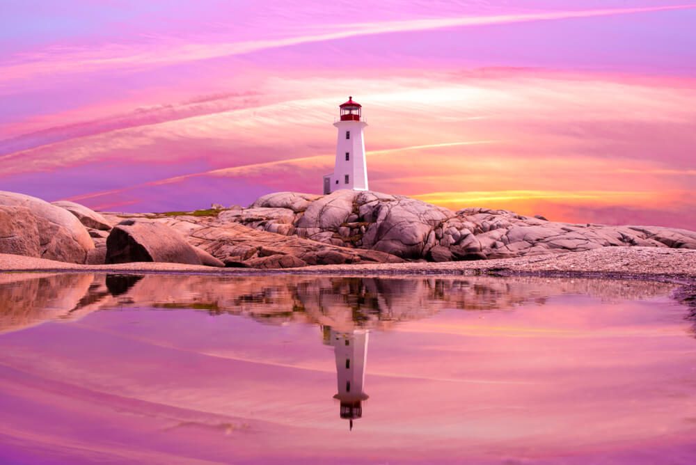 A lighthouse can be seen, illuminated by a pink-purple sunset, in romantic Old Saybrook, CT.