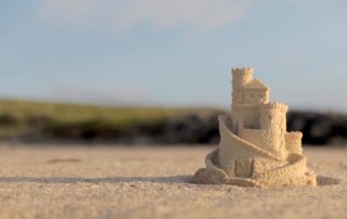 A sandcastle sits on the serene shores of Harvey's Beach.